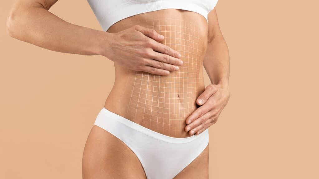 Close up of a woman’s flat stomach with a grid overlayed to show that she’s had a tummy tuck