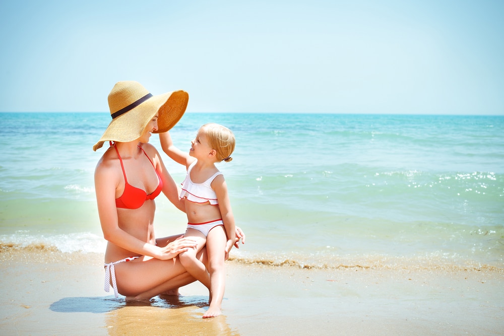 Mom on the beach in a bikini looking great after a mommy makeover in Huntington Beach